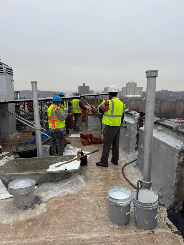 Doon Construction team coordinating rooftop restoration work in Queens